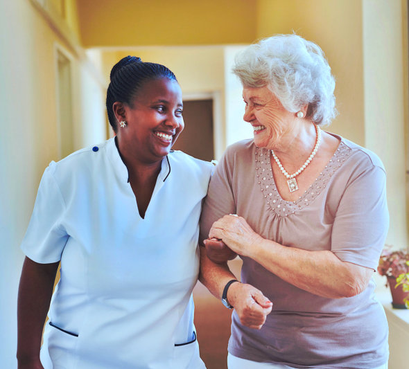 a caregiver having fun with her patient while walking on the hallway